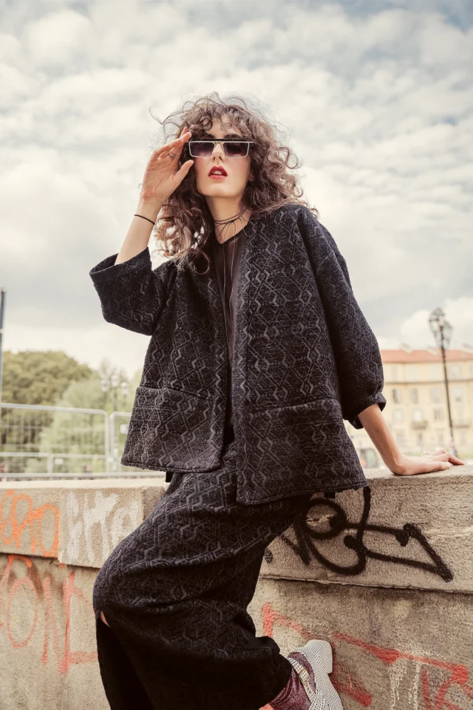 Dettaglio di un look sartoriale marrone con maniche ampie e gonna morbida