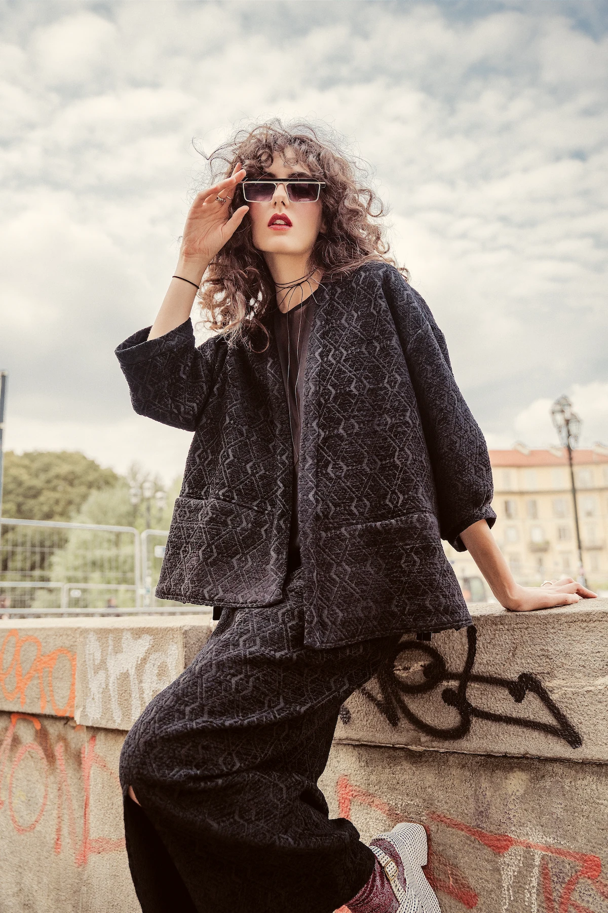 Dettaglio di un look sartoriale marrone con maniche ampie e gonna morbida