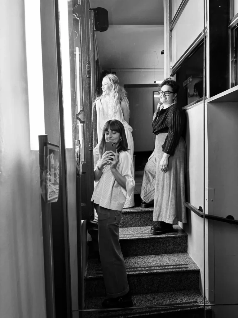 Le tre fondatrici di FE·MA Collective fotografate sulle scale durante il backstage di Everyday Poetry